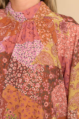 Close up view of this top that features a high elastic neckline and a bohemian pattern in shades of orange, pink, yellow, green, purple, and white.