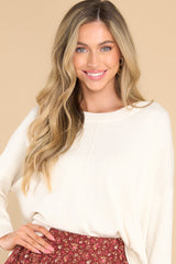 Front view of this sweater that features a crew neckline, a high low hemline, and cuffed sleeves.