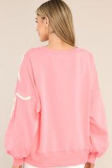 Back view of this sweatshirt that features a crew neckline, dropped shoulders, textured whimsical heart detailing, ribbed cuffed bishop sleeves, and a ribbed hemline.