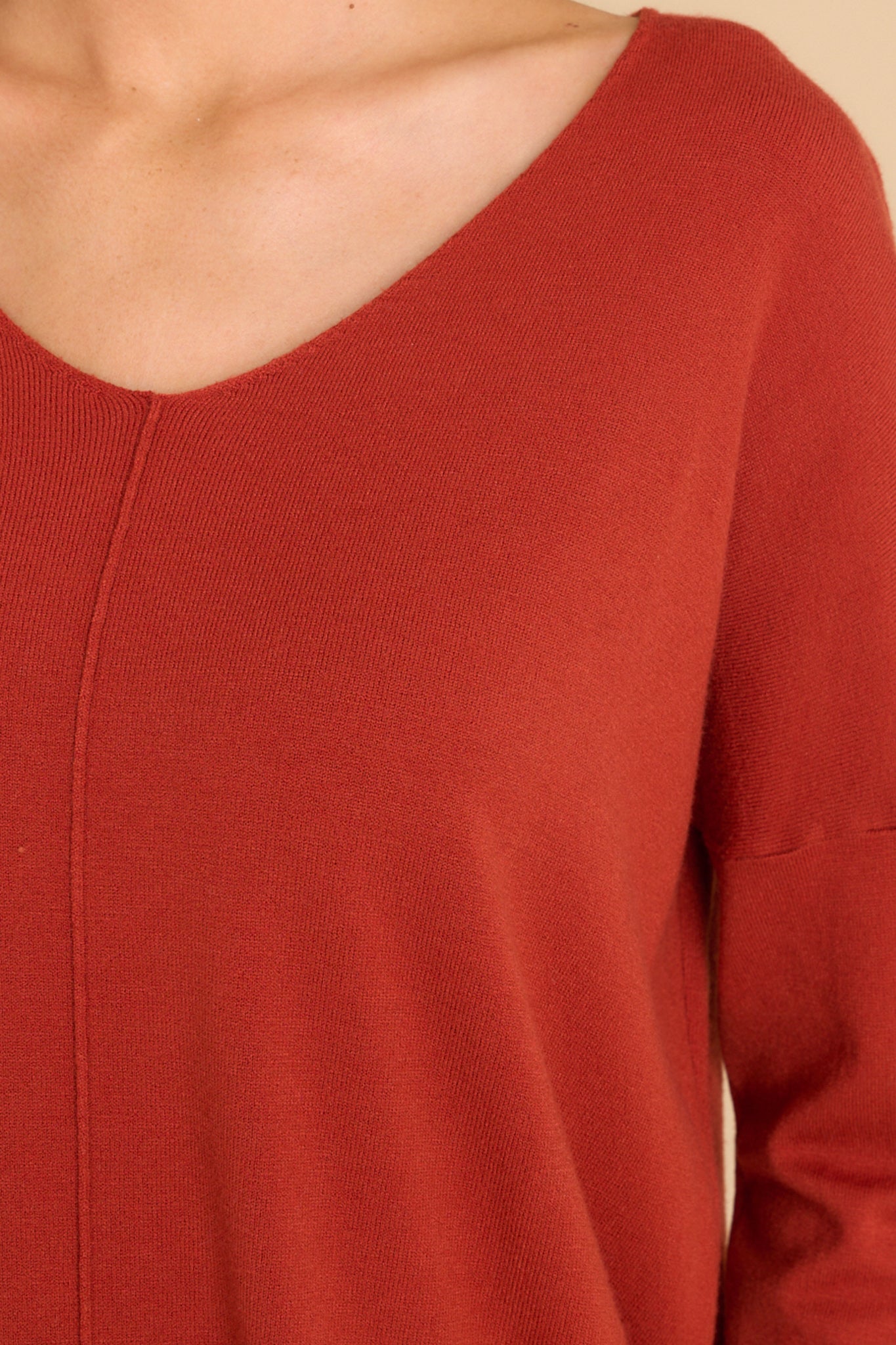 Close up of this sweater that features a seam down the center front and a v-neckline.