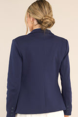 Back view of  this blazer that features a notch lapel collar, shoulder pads, a functional button, faux pockets, and faux buttons on the sleeves.