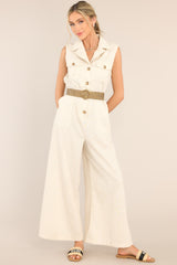 Front view of this jumpsuit that features a notched lapel collared neckline, chest pockets, a functional button front, belt loops, an adjustable belt, an elastic insert at the back of the waist, hip pockets, and a wide leg.