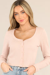 Front view of this cropped top that features a scoop neckline, functional buttons down the front, a waffle knit material, long sleeves, and a cropped hemline.