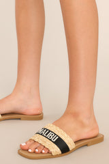 Close up view of these sandals that feature a strap across the top of the foot with the name of a tropical location.