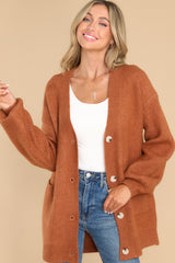 This cozy mustard colored cardigan features a v-neckline, functional buttons down the front, two front pockets, ribbed cuffs, and slight balloon sleeves.