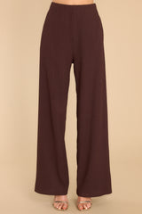 Front view of these pants that feature a high rise, an elastic waistband, functional pockets, and a wide, flowy pant leg.