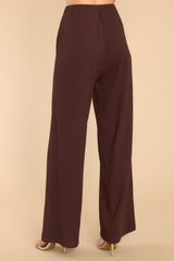 Back view of these pants that feature a high rise, an elastic waistband, functional pockets, and a wide, flowy pant leg.
