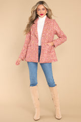 This magenta colored coat features a peak lapel collar, shoulder pads, functional buttons in the front, functional pockets, and is double breasted when buttoned. 