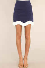 Front view of this skirt that features a high waisted design, a side zipper, and a scalloped hemline.