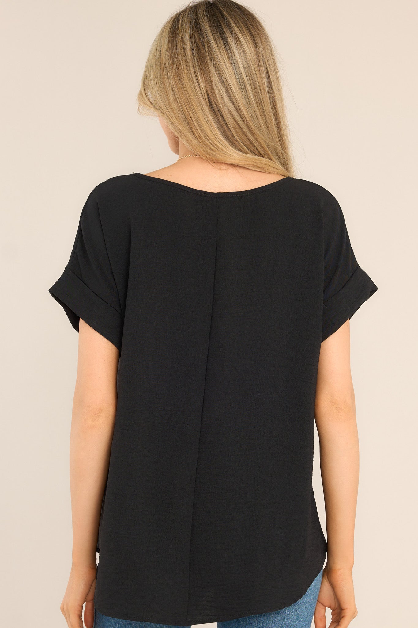 Back view of this top that features a wide crew neckline, rolled & pinned short sleeves, and a relaxed fit.