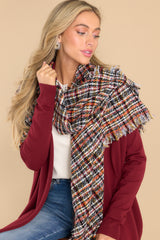 This black and orange plaid knit scarf features a frayed edge design.