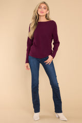 This maroon sweater features a round neckline and a soft stretchy material.