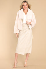 This ivory jacket features a folded collar, a super soft faux fur material, and a cropped hemline.