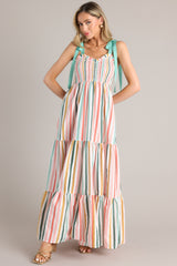This multi-colored striped dress features a v-neckline, adjustable self-tie straps, a smocked bust, and flowy tiers down the skirt.