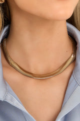 This gold necklace features a thick, solid gold chain necklace with a lobster clasp. 