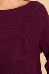 Close up view of this sweater that features a round neckline and a soft knit material.