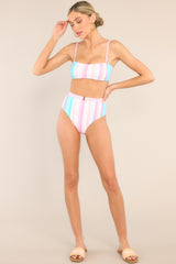 Full body view of these bottoms that feature a high rise, a faux-belted waistband, a cheeky style, and a colorful stripe pattern throughout.