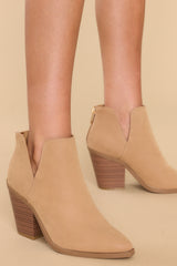 These tan booties feature a pointed toe, a stacked heel, and a slit on the ankle.