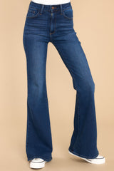 Close up front view of these jeans that feature a high waist, belt loops, front and back pockets, and a hemmed and flared bottom.