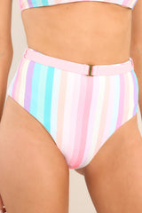 These pink multi bottoms feature a high rise, a faux-belted waistband, a cheeky style, and a colorful stripe pattern throughout.