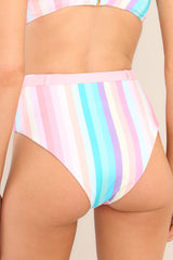 Back view of these bottoms that feature a high rise, a faux-belted waistband, a cheeky style, and a colorful stripe pattern throughout.