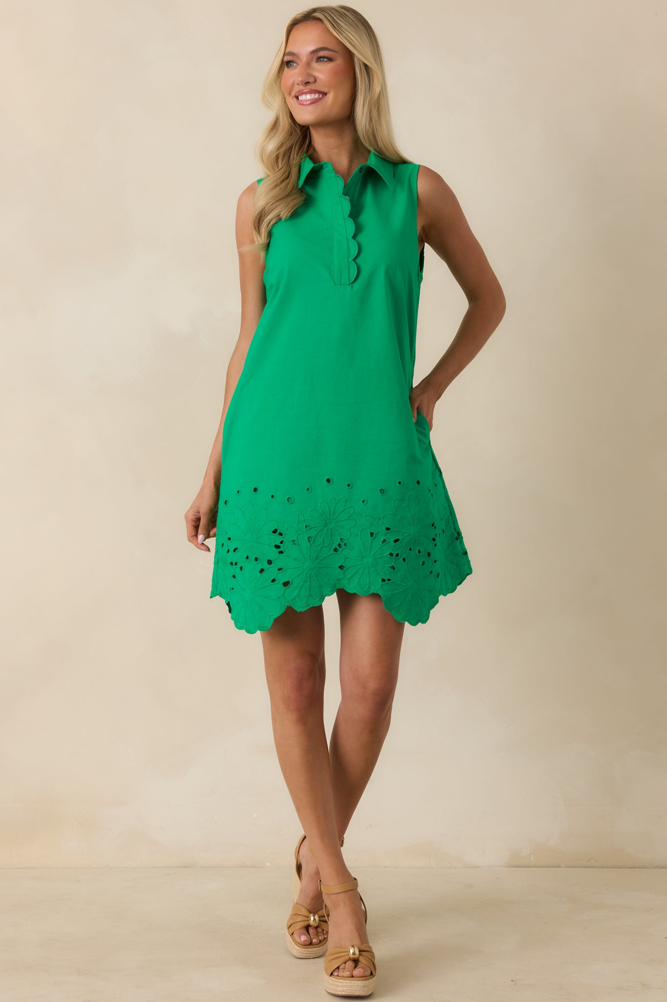 Lightweight green cotton mini dress with a pull-on silhouette, side pockets, and a softly structured sleeveless cut.