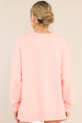 Back view of this top that features a ribbed crew neckline, dropped shoulders, exposed seams, ribbed cuffed sleeves, and a ribbed split high-low hemline.