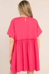 Back view of this dress that features a round neckline, a keyhole cutout at the back of the neck with a button closure, short sleeves, ruffle detailing along the waistline, and functional pockets at the hips.