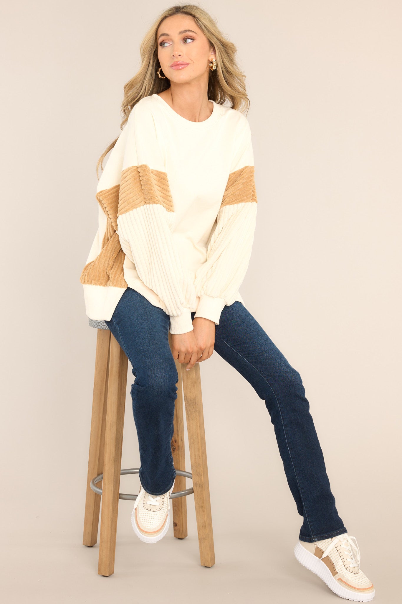 This ivory sweatshirt features a ribbed crew neckline, soft & textured detailing on the sleeves and sides, and a split hemline.