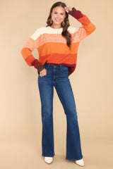 Full body view of this sweater that showcases the ombre effect of the fabric starting with ivory and gradually getting darker in color with orange.