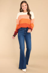 Full body view of this sweater that features a round ribbed neckline, long sleeves, and a fun ombre striped design.