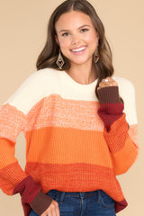 Front view of this sweater that features a round ribbed neckline, long sleeves, and a fun ombre striped design.