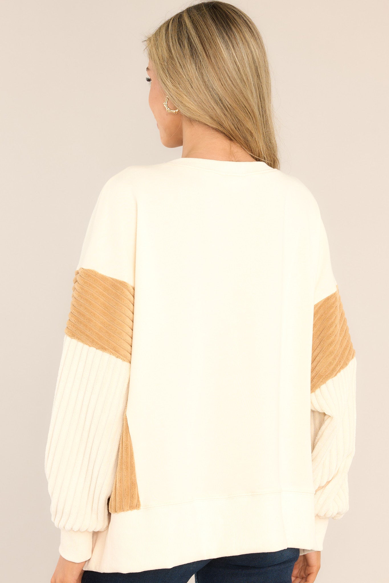Back view of this sweatshirt that features a ribbed crew neckline, soft & textured detailing on the sleeves and sides, and a split hemline.