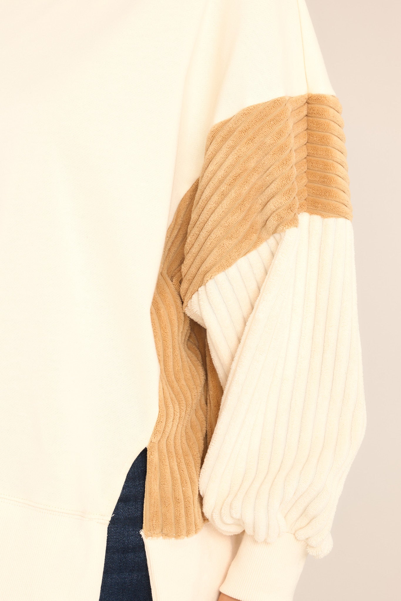 Close up view of this sweatshirt that features a ribbed crew neckline, soft & textured detailing on the sleeves and sides, and a split hemline.
