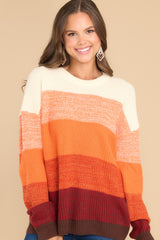 This multi-colored sweater features a round ribbed neckline, long sleeves, and a fun ombre striped design.