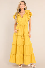 This all yellow dress features a v-neckline with a self-tie closure, ruffled flutter sleeves, a drawstring waistband, and a long, flowy skirt.