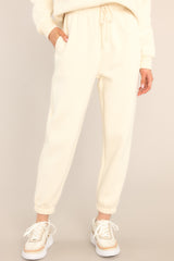 These ivory joggers feature a self-tie drawstring waist, pockets, and cuffed elastic ankles.