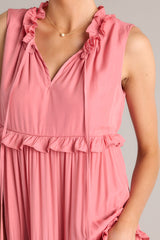 Close up view of this dress that features a ruffled v-neckline with a self-tie closure, a sleeveless design, and a flowy skirt with subtle ruffle detailing throughout.