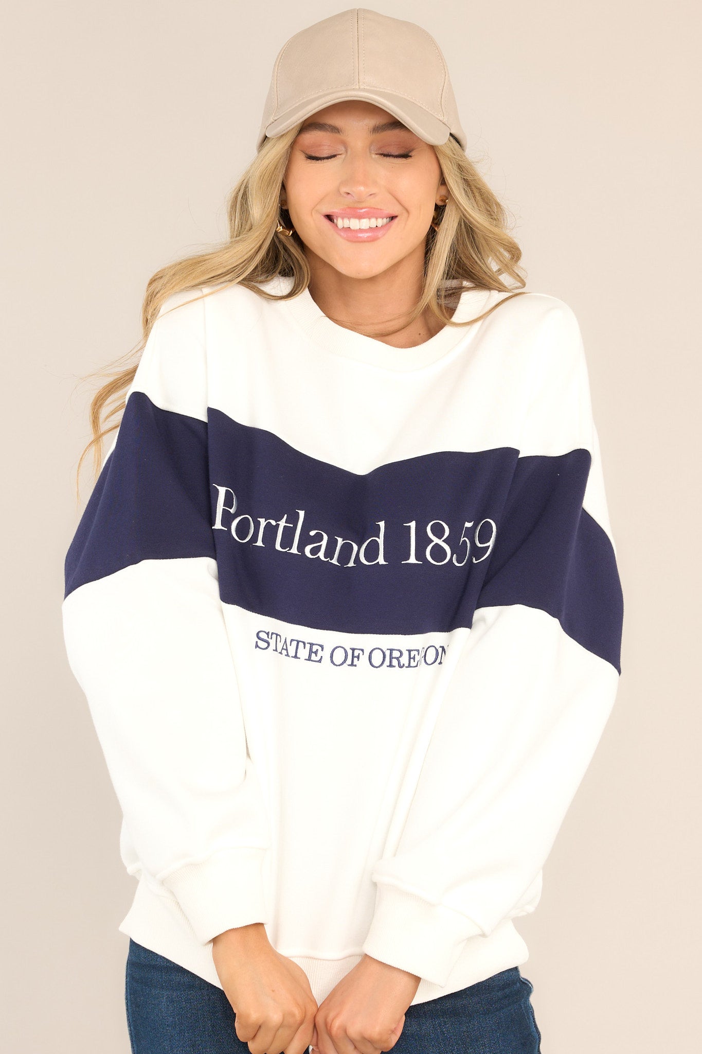 This white and navy sweatshirt features embroidered Portland text, a crew neckline, ribbed hems, and a cozy oversized fit. 