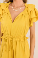 Close up view of this dress that features a v-neckline with a self-tie closure, ruffled flutter sleeves, a drawstring waistband, and a long, flowy skirt.