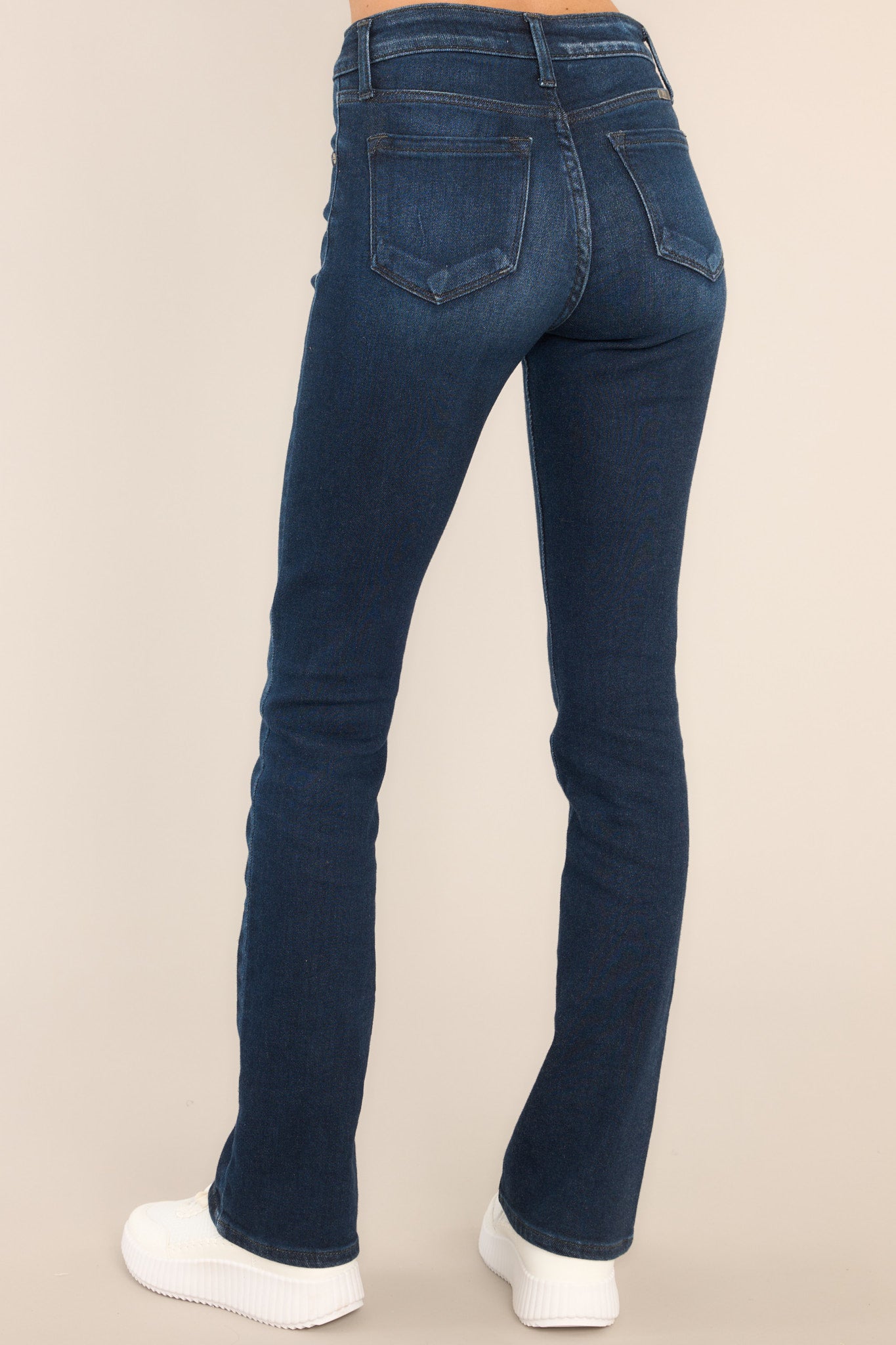 Back view of these jeans that feature a skinny jean style a high waist, 5 pocket detailing, belt loops, and a zipper button closure.
