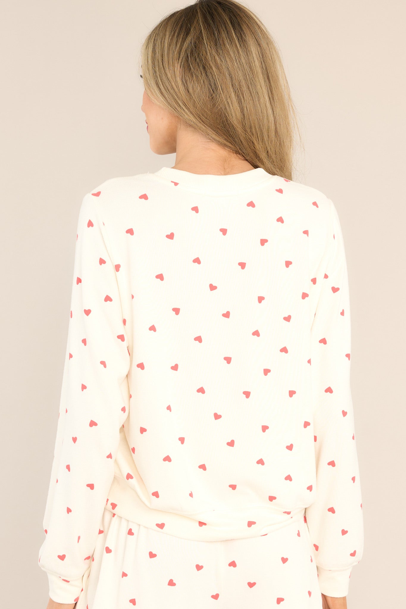 Back view of this top that features a ribbed crew neckline, an all-over festive print, cuffed long sleeves, and a cuffed hemline.