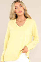 This yellow weekender features a v-neckline, dropped shoulders, ribbed cuffed sleeves, and a split ribbed hemline.