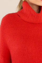 Detailed shot red sweater that features dropped shoulders and a cowl-like turtleneck. 