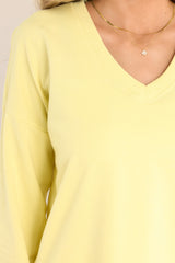 Close up view of this weekender that features a v-neckline, dropped shoulders, ribbed cuffed sleeves, and a split ribbed hemline.