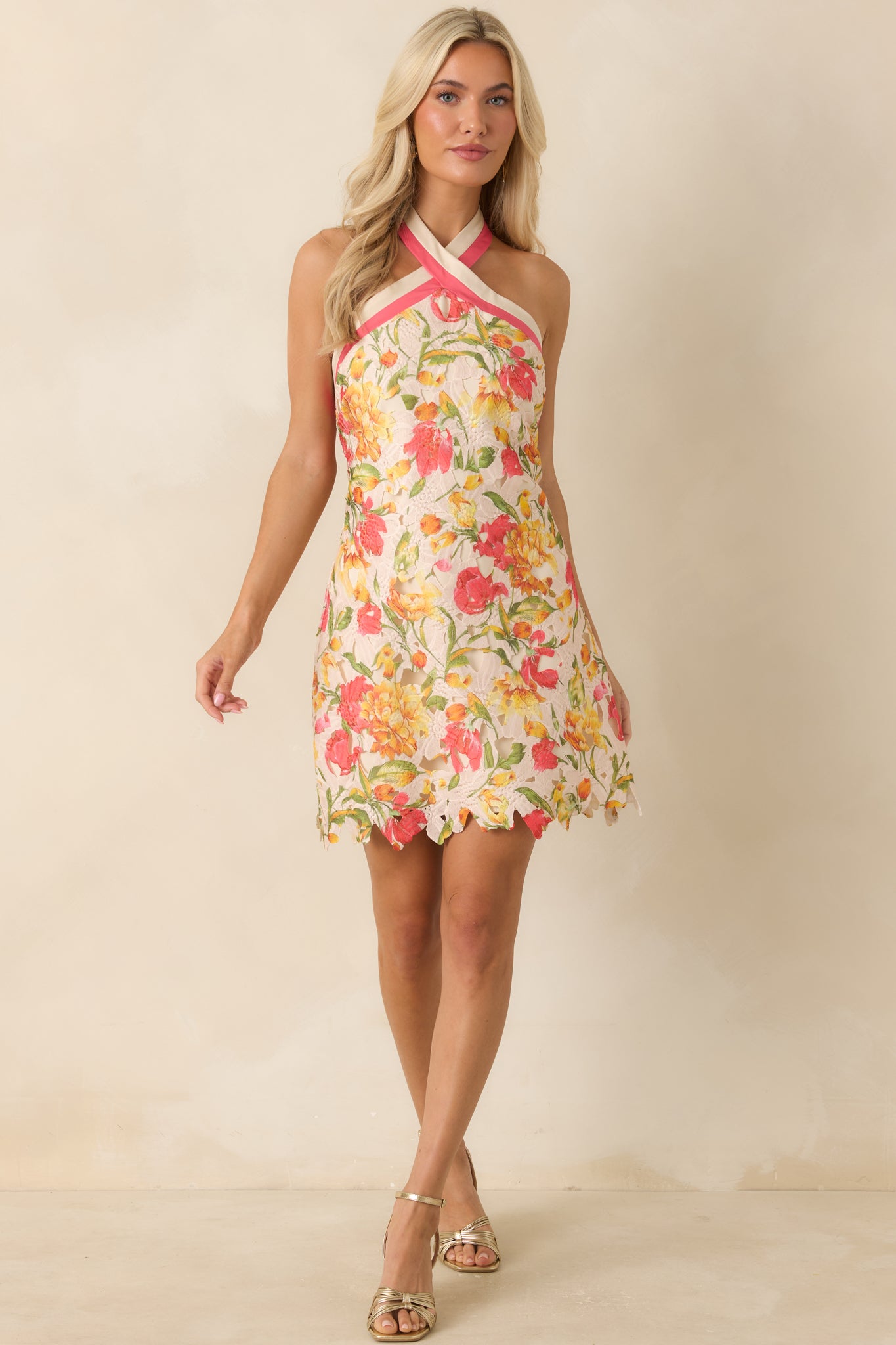 Ivory mini dress featuring a floral printed lace overlay, contrast coral pink halter neckline, and a fitted bodice that flows into an A-line silhouette.
