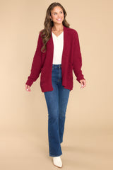 This red wine colored cardigan features a soft, chunky knit design, functional pockets, and small slits up the sides.