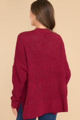 Back view of this cardigan that features a soft chunky knit design, functional pockets, and small slits up the sides.