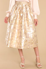 Front view of this skirt that features a high waist, raised gold flower details, waist pockets, a hemmed bottom, and a back zipper closure.