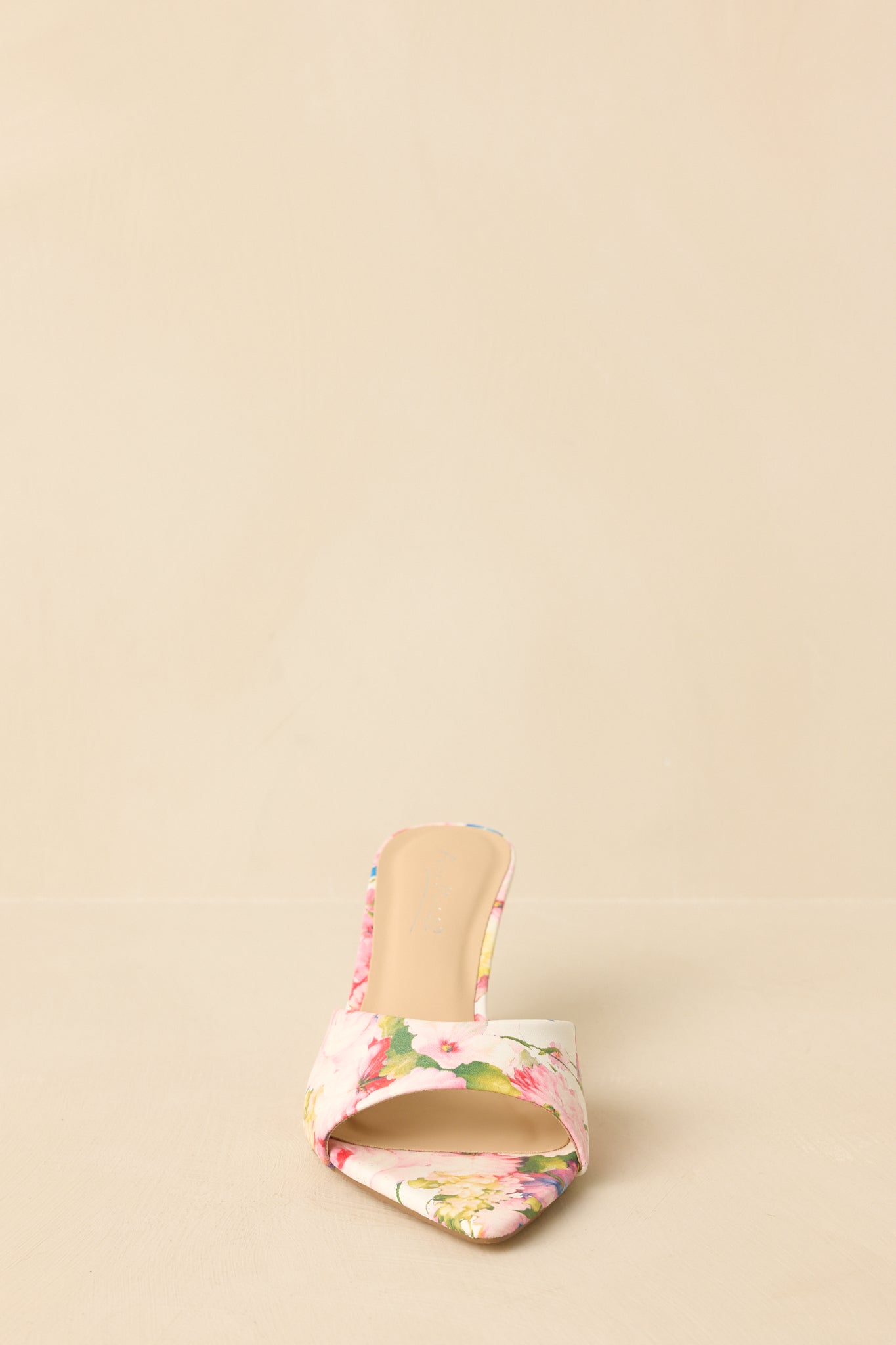 Front view of pink floral kitten heel mules displaying open pointed toe and patterned upper.